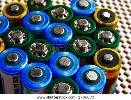 Macro of assorted rechargeable battery tops, on patterned background