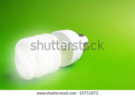 Compact fluorescent light bulb on green (green energy)