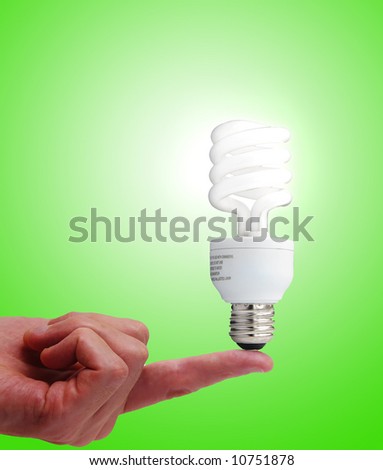 Compact fluorescent bulb on a finger, on green
