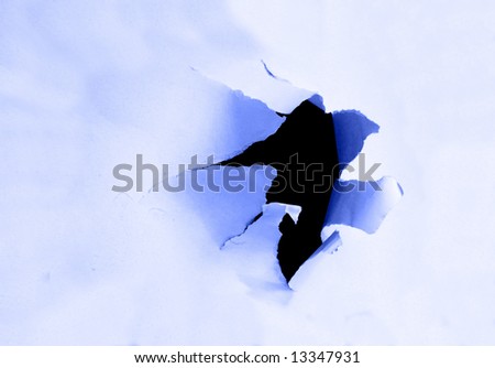 Side view of a torn jagged hole in paper