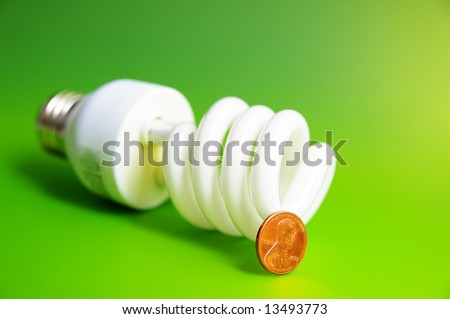 light bulb with a penny, (energy costs), on green