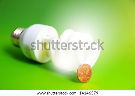 light bulb with a penny, (energy costs), on green