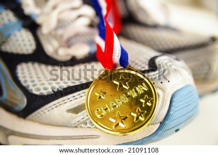 gold medal and running shoes, closeup