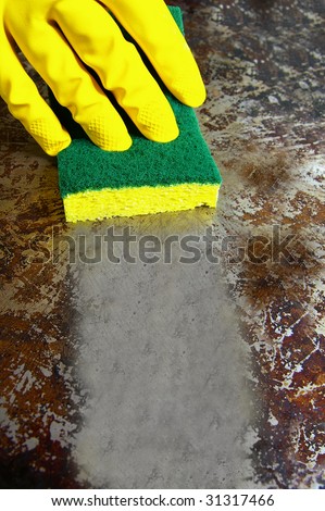 sponge wiping a dirty metal surface clean