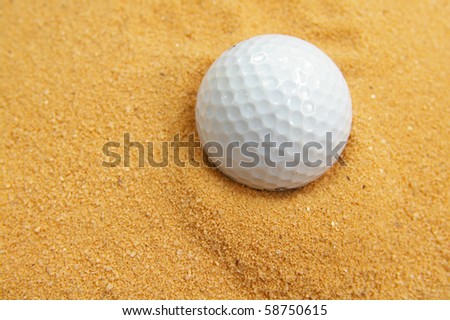 closeup of a golf ball in a sand trap