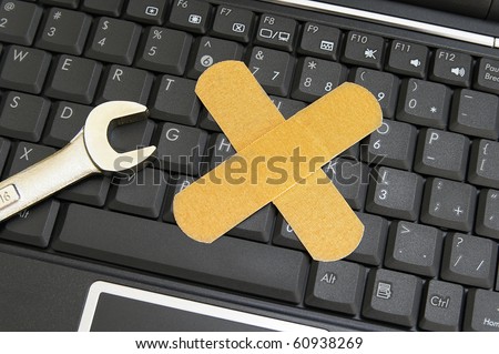 pc keyboard and wrench with bandage - computer repair