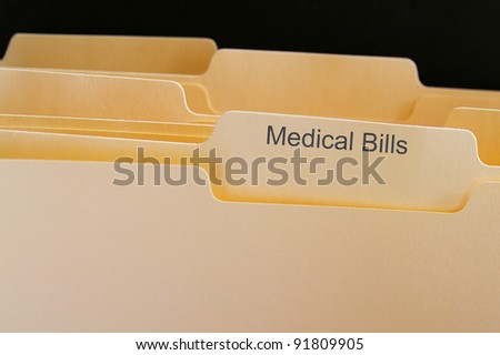 Folders with Medical Bills test, on black