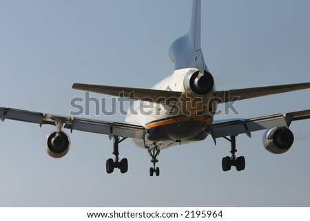 Close image of a jet plane landing with landing gears down