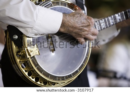 Black and white image of a banjo being played by an older gentleman.