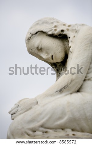 Statue of a crying girl atop a tomb in an historic New Orleans cemetery