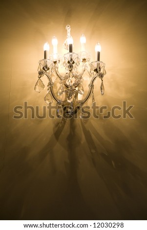 A tungsten bulb wall sconce casting an intricate shadow