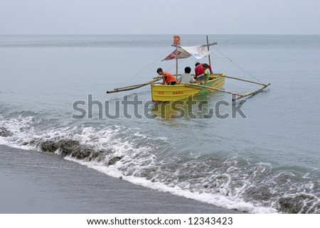 Luzon Beach, Philippines 2005:  A traditional outrigger canoe (bangka) with passengers.