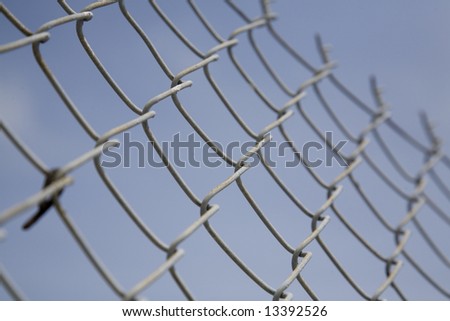 Narrow depth of field image of a metal chain-link fence.