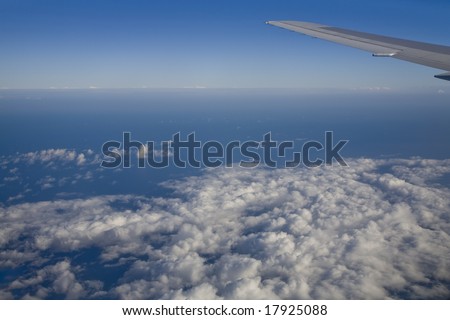 Horizontal view of the ocean outside a jumbo jet plane window.