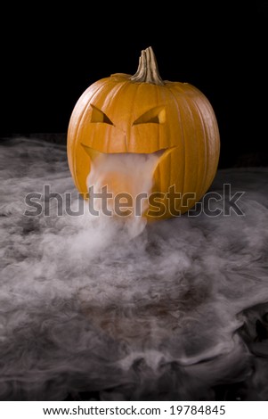 Vertical image of a Jack-o-Lantern with mist pouring from it\'s mouth