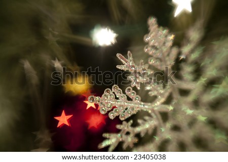 Horizontal image of a plastic snow-flake ornament taken with a selective focus (lens-baby) lens, with star shaped bokeh.