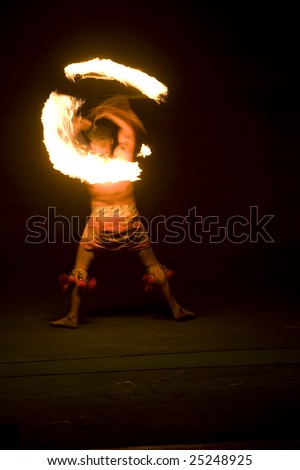 Vertical iamge of a Hawaiian fire dancer twirling a torch.