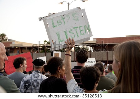 ALHAMBRA, CA - AUGUST 11: A woman holds up a sign that reads, 