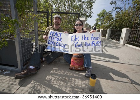 LOS ANGELES - AUGUST 21: A young couple holds signs supporting healthcare reform outside a climate reform panel with Henry Waxman (D-CA)  at UCLA on August 21, 2009 in Los Angeles.