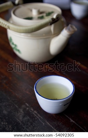 Vertical image of green tea served in a traditional cup in a Japanese tea house.