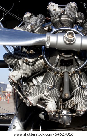 Vertical image of a shiny rotary aircraft engine on an old bi-plane.