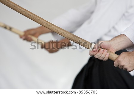 Close up image of wooden swords (bokken) held by Japanese swordmanship practitioners.