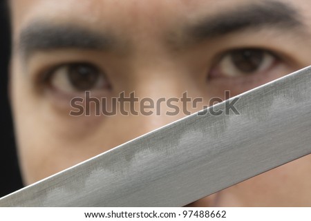 stock-photo-close-up-image-of-an-asian-man-looking-passed-a-samurai-sword-blade-97488662.jpg