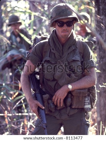 American Army Soldier patrols with an M16 in hand during in 1972. High film grain.