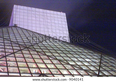 The Rock and Roll Hall of Fame and Museum of Cleveland, Ohio with windows lit up at night.
