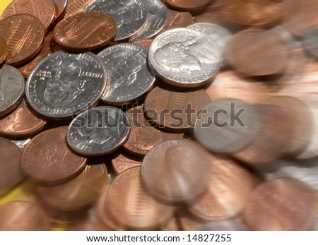 Blurred spare change:  A selection of American money coins including pennies, dimes, nickles, and quarters complete with a radial blur effect