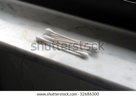 Four cotton swabs sitting on a window sill