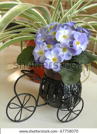 decorative flowers in a decorative supports a carriage on wheels and flowers pots
