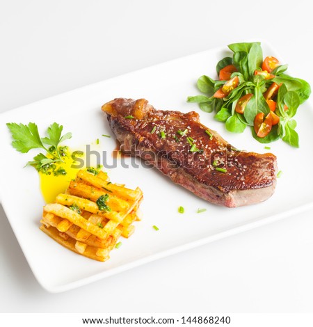 Beef Steak with salad and Fried chips.