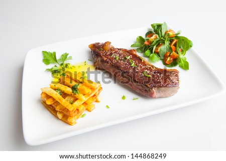 Beef Steak with salad and Fried chips.