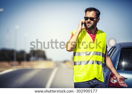 Worried man talking with insurance company after car breakdown.