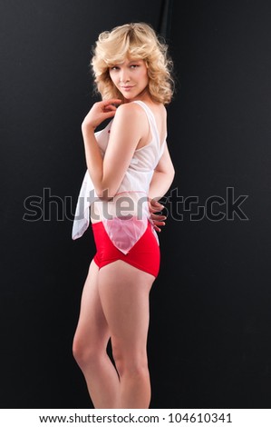 Pretty young blonde in a see through blouse and red shorts