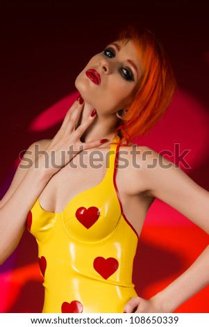 Beautiful pale redhead dressed in yellow latex