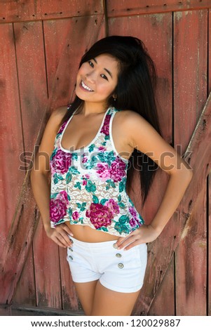 Pretty young Laotian woman in a flower print blouse and white shorts