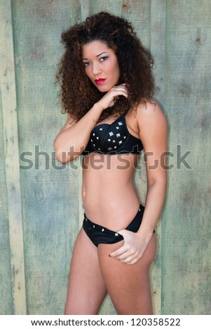 Beautiful wavy haired multiracial woman in a black bra and shorts