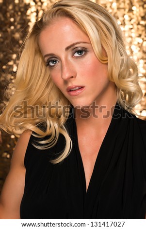 Portrait of a pretty young blonde in a black sleeveless blouse