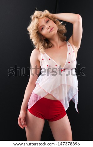 Pretty young blonde in a sheer blouse and red shorts