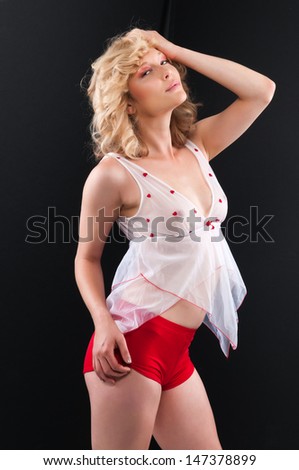 Pretty young blonde in a sheer blouse and red shorts