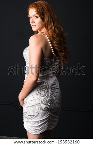 Pretty young freckled redhead in a strapless gray dress