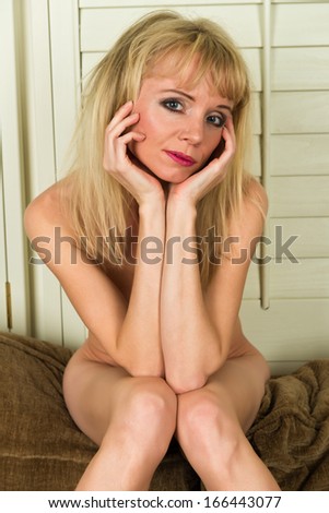 Petite Swedish blonde woman nude on a sofa