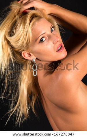 Beautiful petite blonde woman nude on black