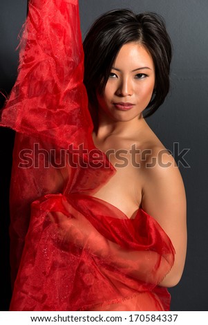 Beautiful young Chinese woman wrapped in red tulle