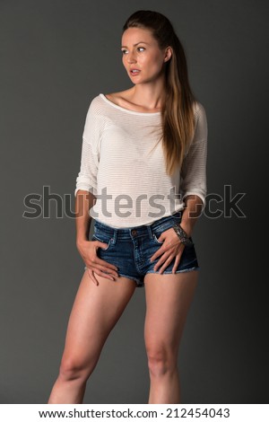 Pretty Eastern European blonde in a long sleeved blouse and jeans shorts