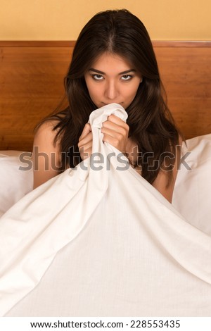 Beautiful petite Eurasian woman nude in bed