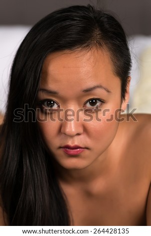 Closeup on the face of a pretty Korean woman lying in bed