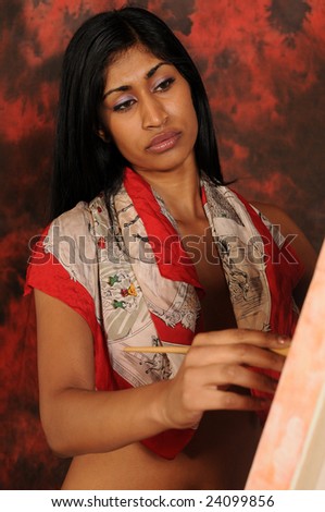 Beautiful young Indian woman working on a canvas